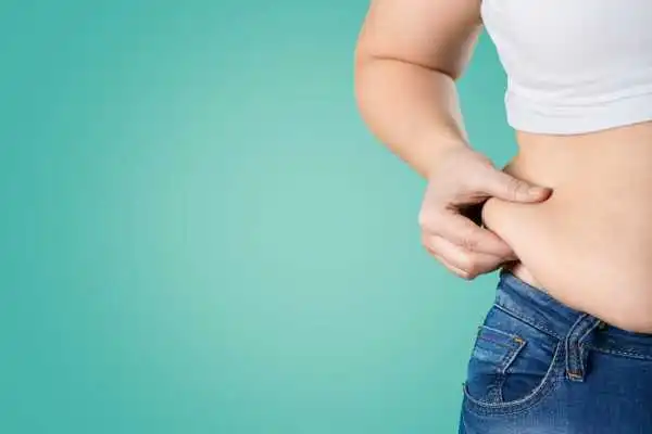 Image of woman pinching her love handles to show weight gain Birchills